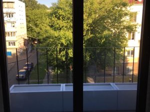 Уличные кашпо за окном квартиры